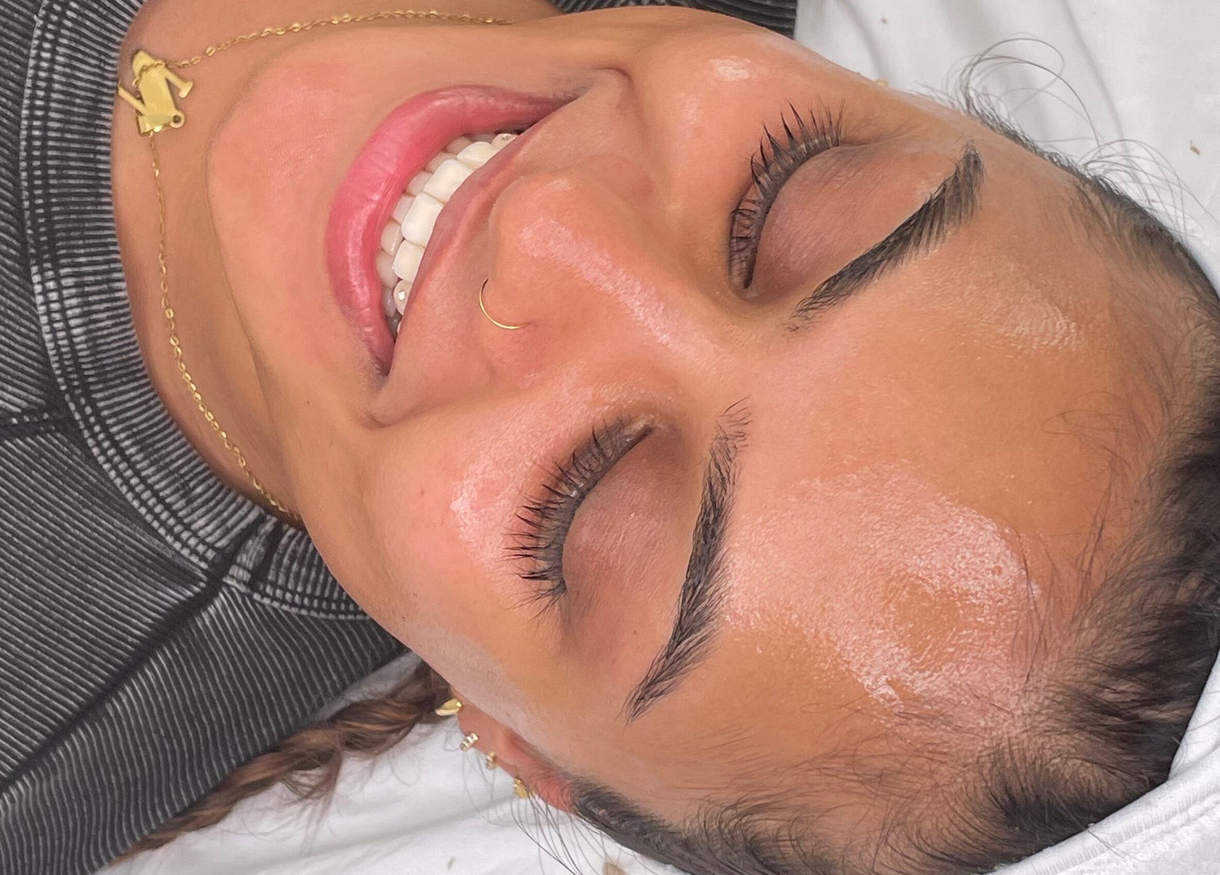Smiling woman with glowing skin after facial at Dgtheaesthetician, London, England, GB.