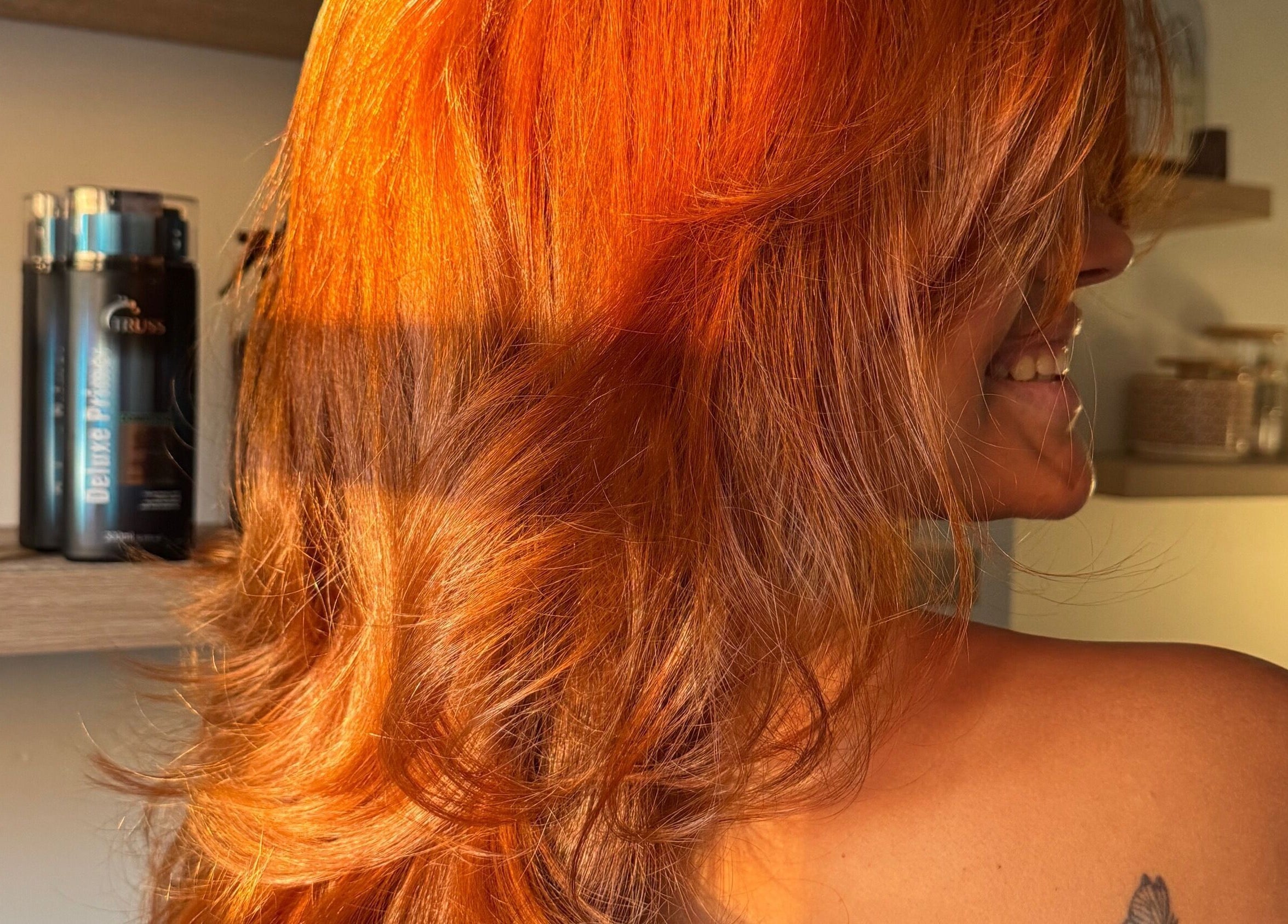 Schitterende rode haarstijl bij Dary in Kortrijk, Vlaams Gewest, BE, met producten op de achtergrond.