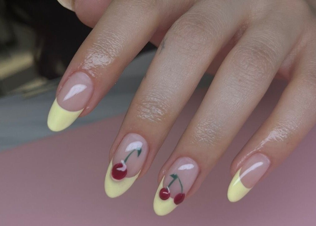 Stijlvolle nagels met kersontwerp en gele punt bij Dary in Kortrijk, Vlaams Gewest, BE.