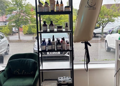 Product display at Lahives Glamsquad 4 Ivy Farm Court, Hale showcasing beauty items and comfy seating.
