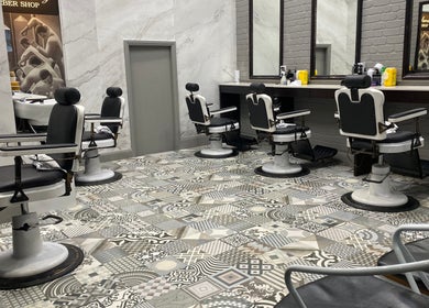 Stylish interior of Broadway Barbershop in Ultimo, NSW, AU with vintage barber chairs and decorative flooring.