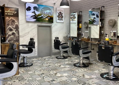 Sleek interior of Broadway Barbershop, Ultimo, NSW, AU, featuring modern black styling chairs and artistic decor.