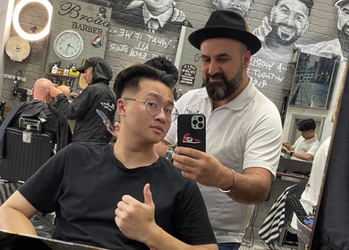 Customer at Broadway Barbershop in Ultimo, NSW, AU getting a haircut selfie with barber.