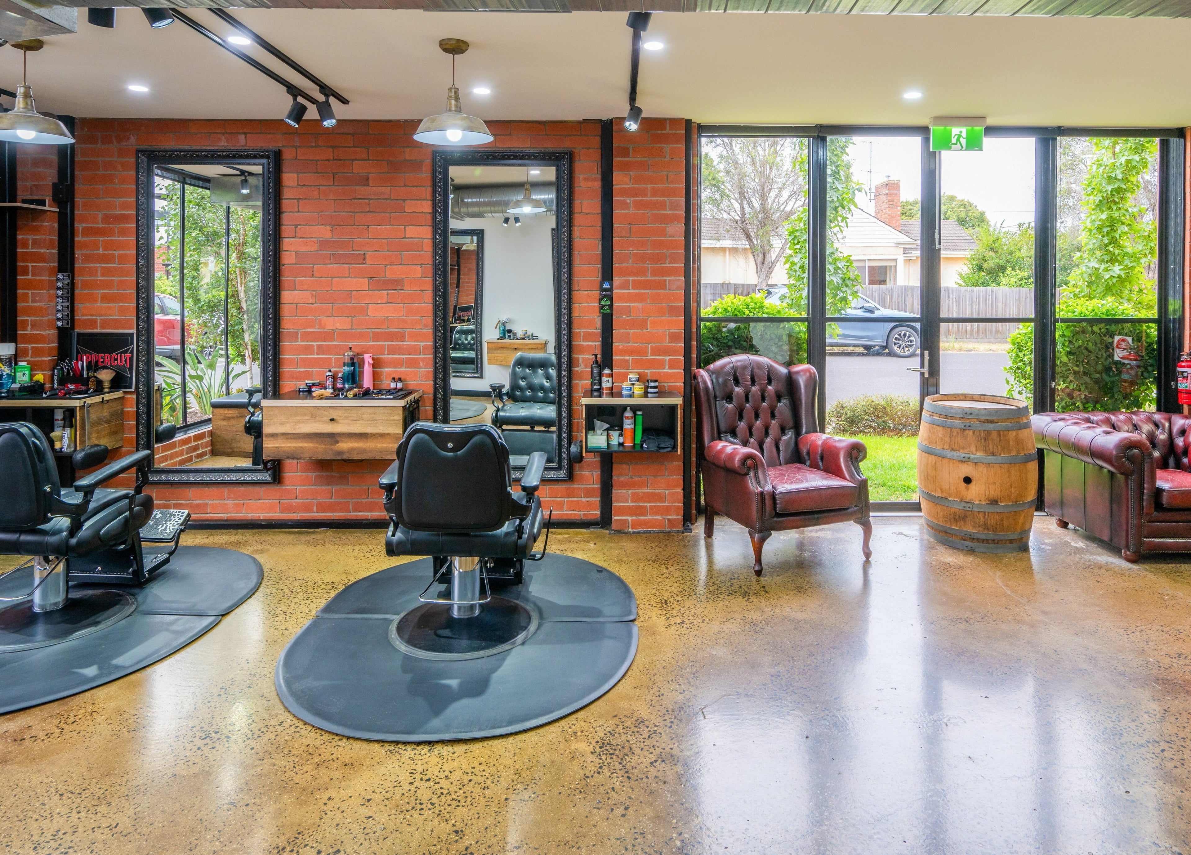 Inside Rex and Ross Barber - Newtown, cozy chairs and mirrors enhance the style in Newtown, Victoria, AU.