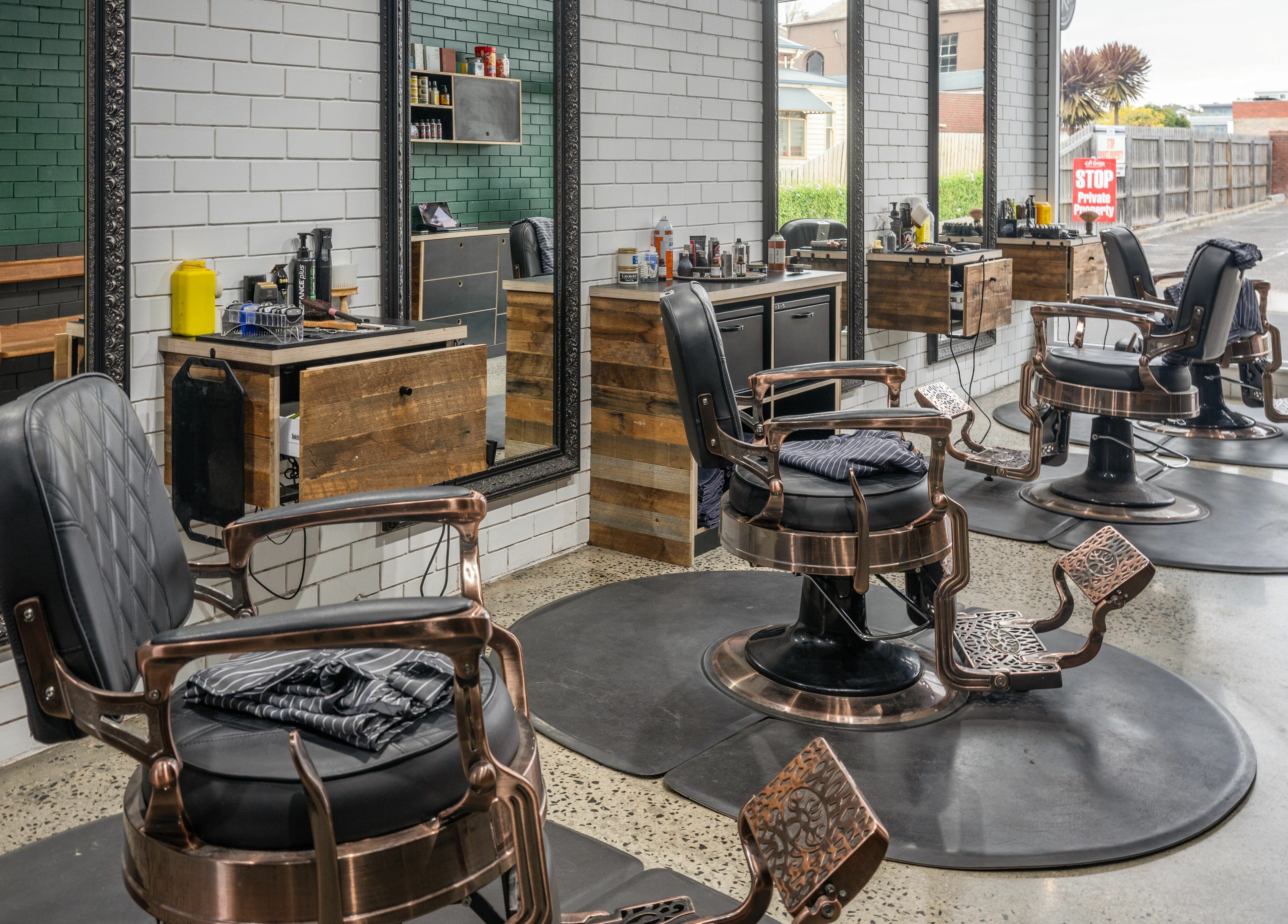 Interior of Rex and Ross Barber - Geelong West in Geelong West, Victoria, AU with rustic chairs and mirrors.