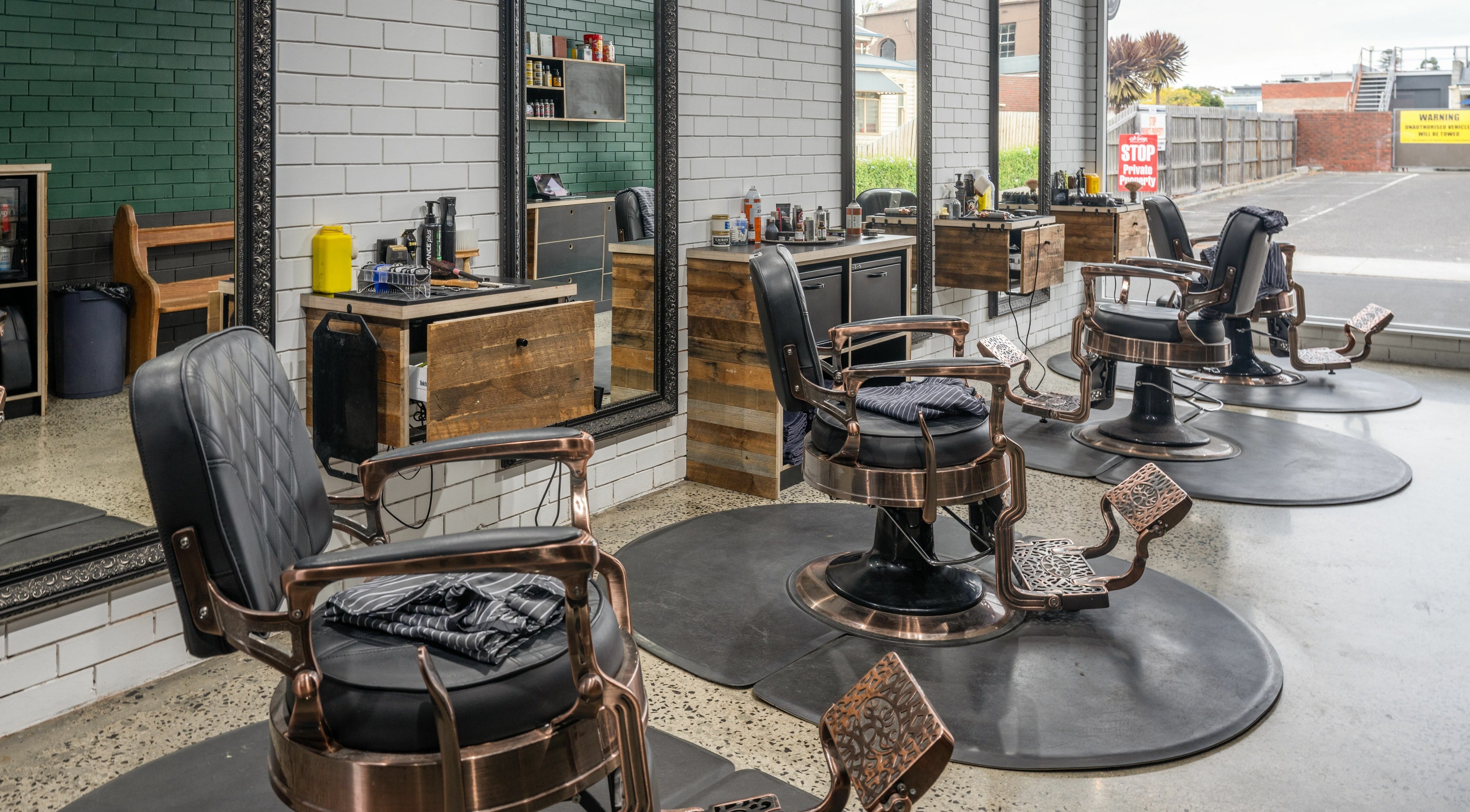 Interior of Rex and Ross Barber - Geelong West in Geelong West, Victoria, AU with rustic chairs and mirrors.
