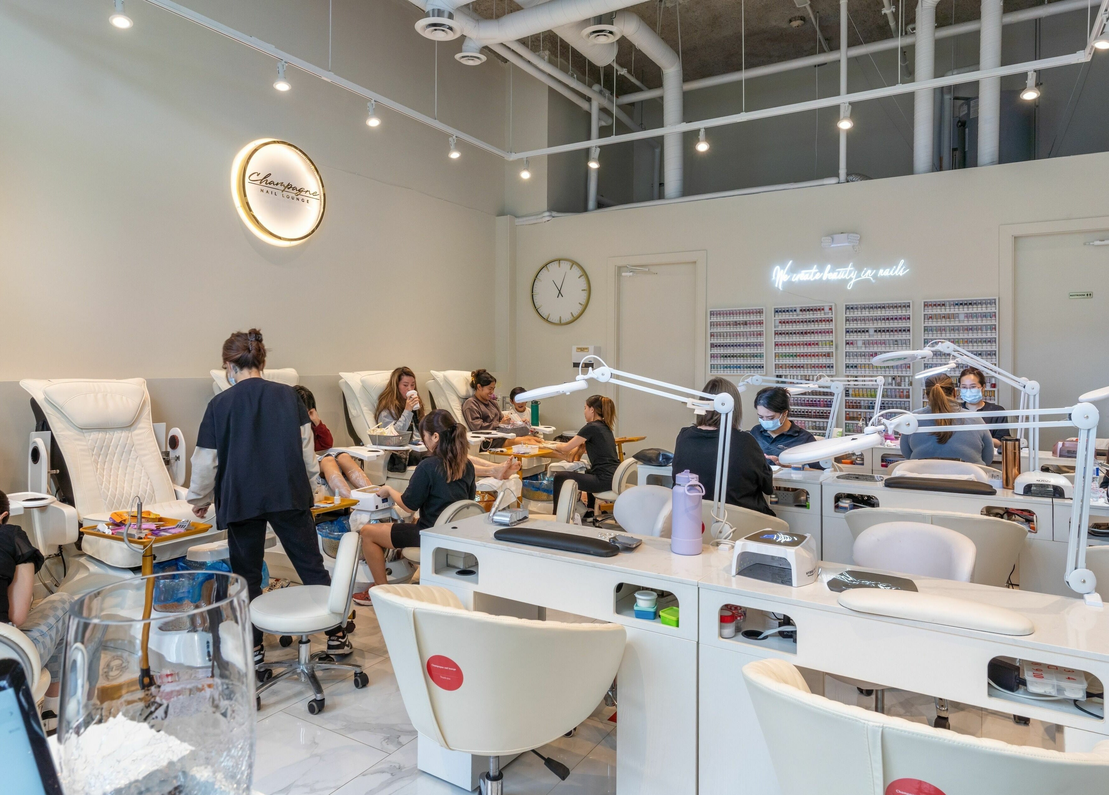 Interior of Champagne Nail Lounge at the Quay, New Westminster, British Columbia, CA, full of clients enjoying manicures.