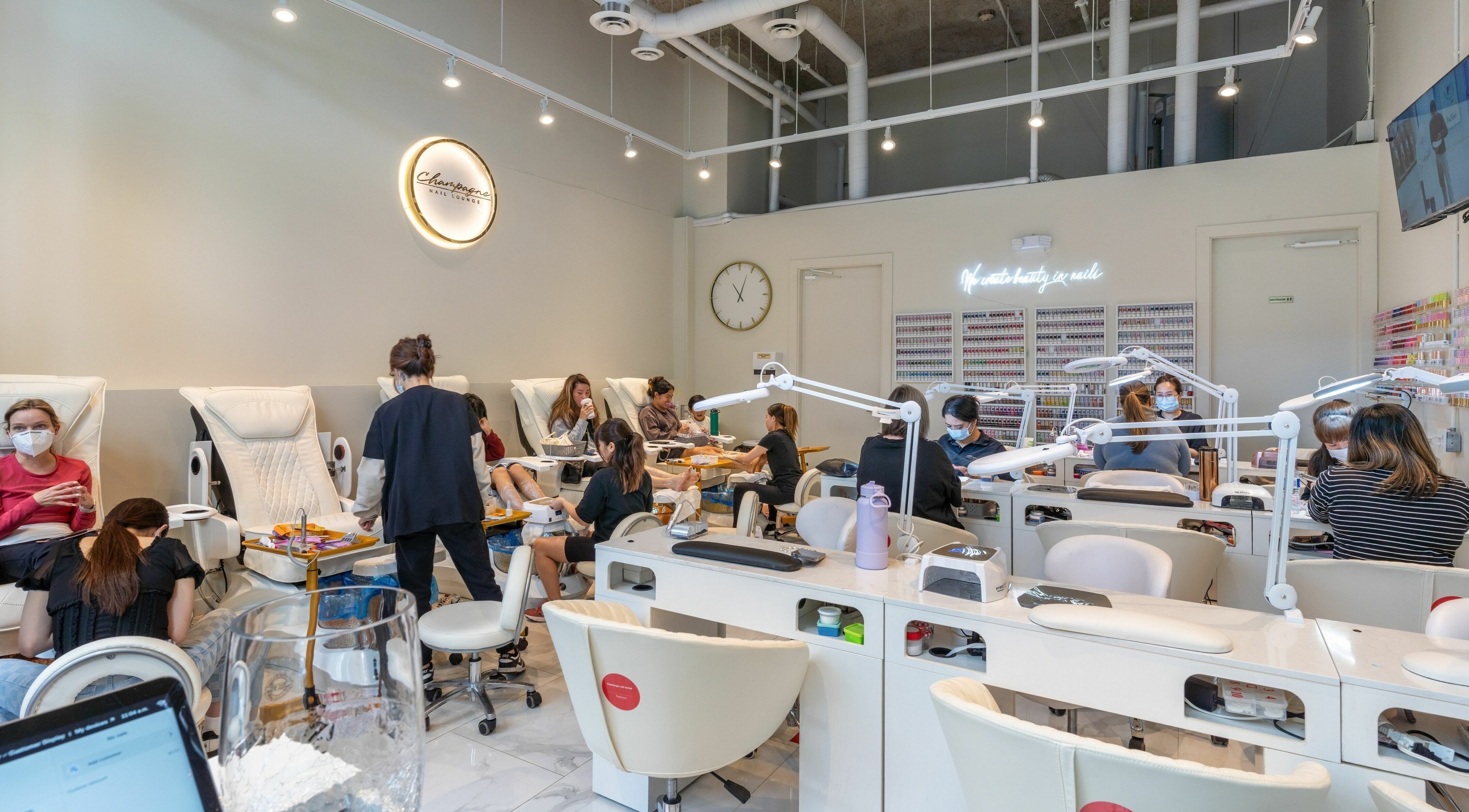 Interior of Champagne Nail Lounge at the Quay, New Westminster, British Columbia, CA, full of clients enjoying manicures.