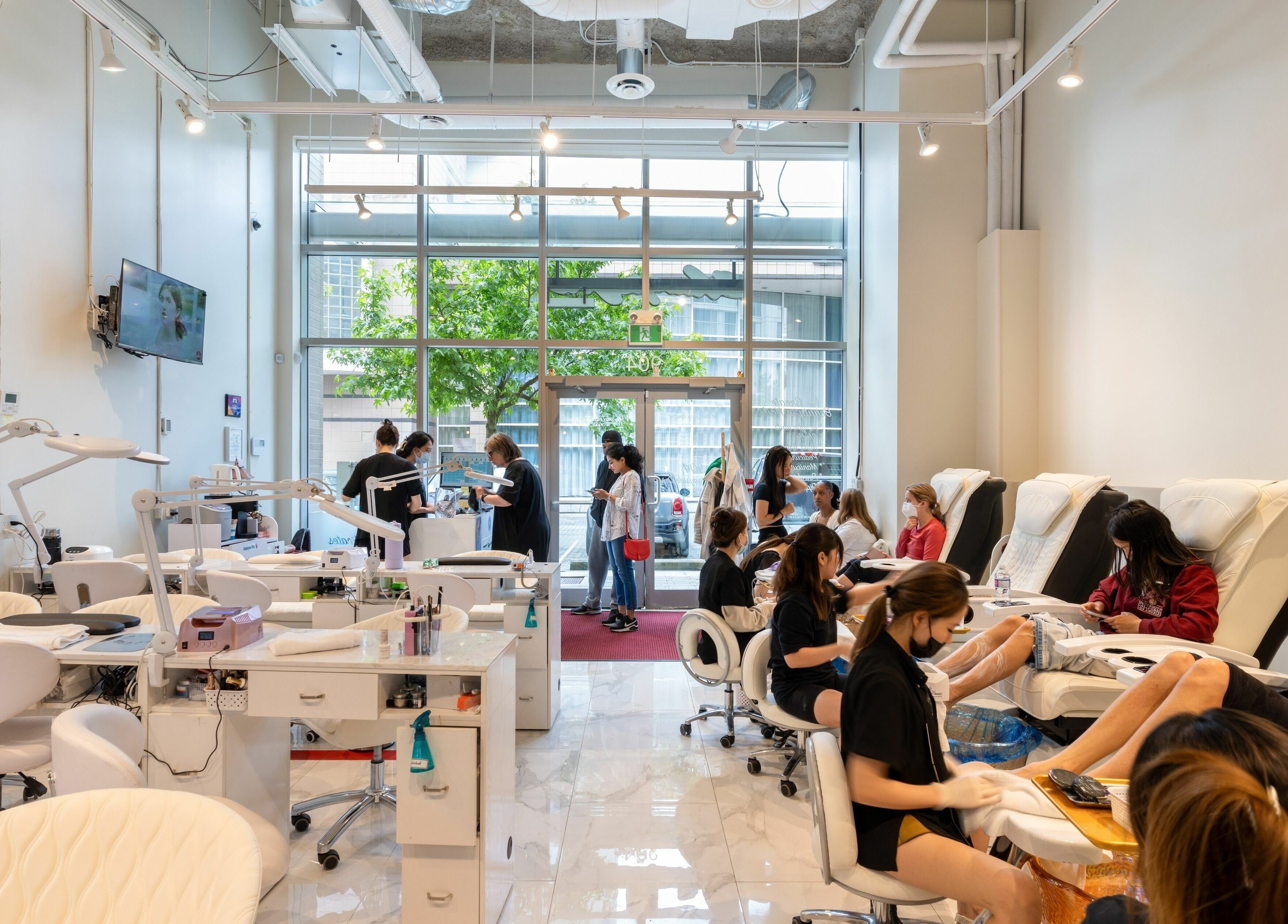 Clients enjoying services at Champagne Nail Lounge at the Quay, New Westminster, BC, in a modern, bright setting.