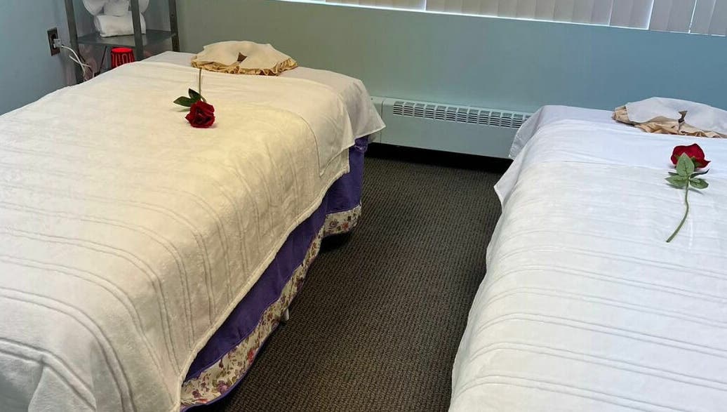 Peaceful massage room at RTC Massage, Reston, Virginia, US with two beds adorned with red roses.