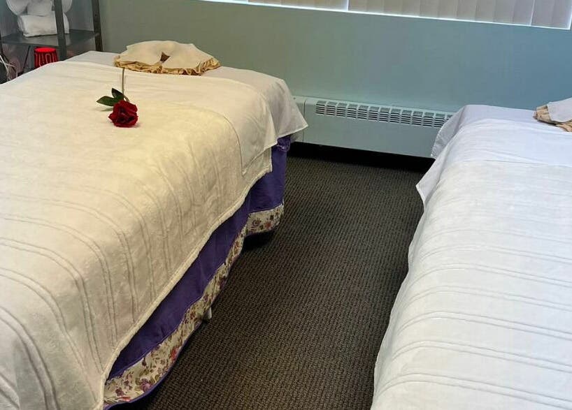 Peaceful massage room at RTC Massage, Reston, Virginia, US with two beds adorned with red roses.