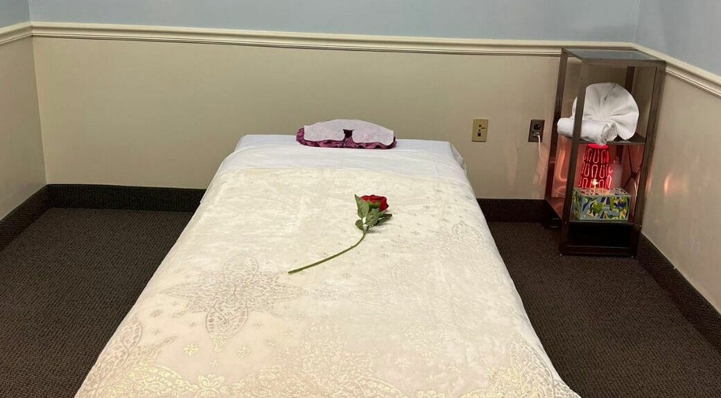 Tranquil massage room at RTC Massage, Reston, Virginia, US with a rose on the bed for relaxation.