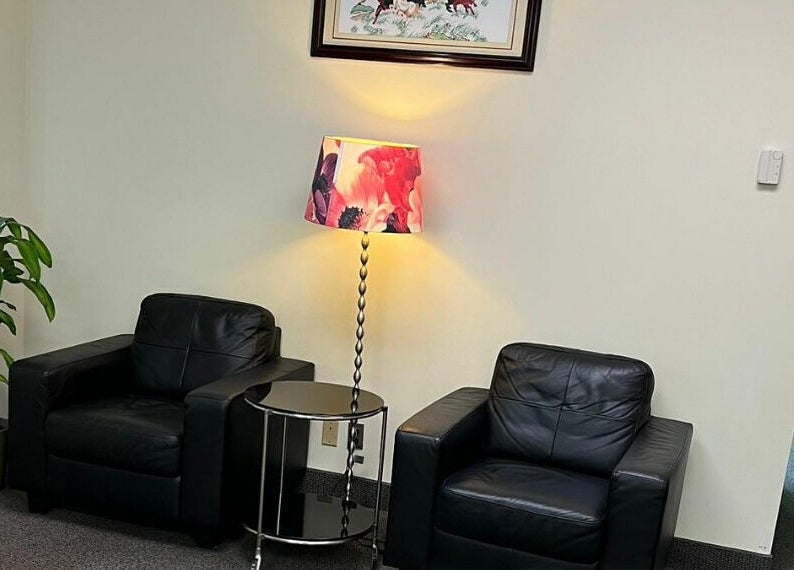 Comfortable seating area at RTC Massage in Reston, Virginia, US with leather chairs and a floral lamp.