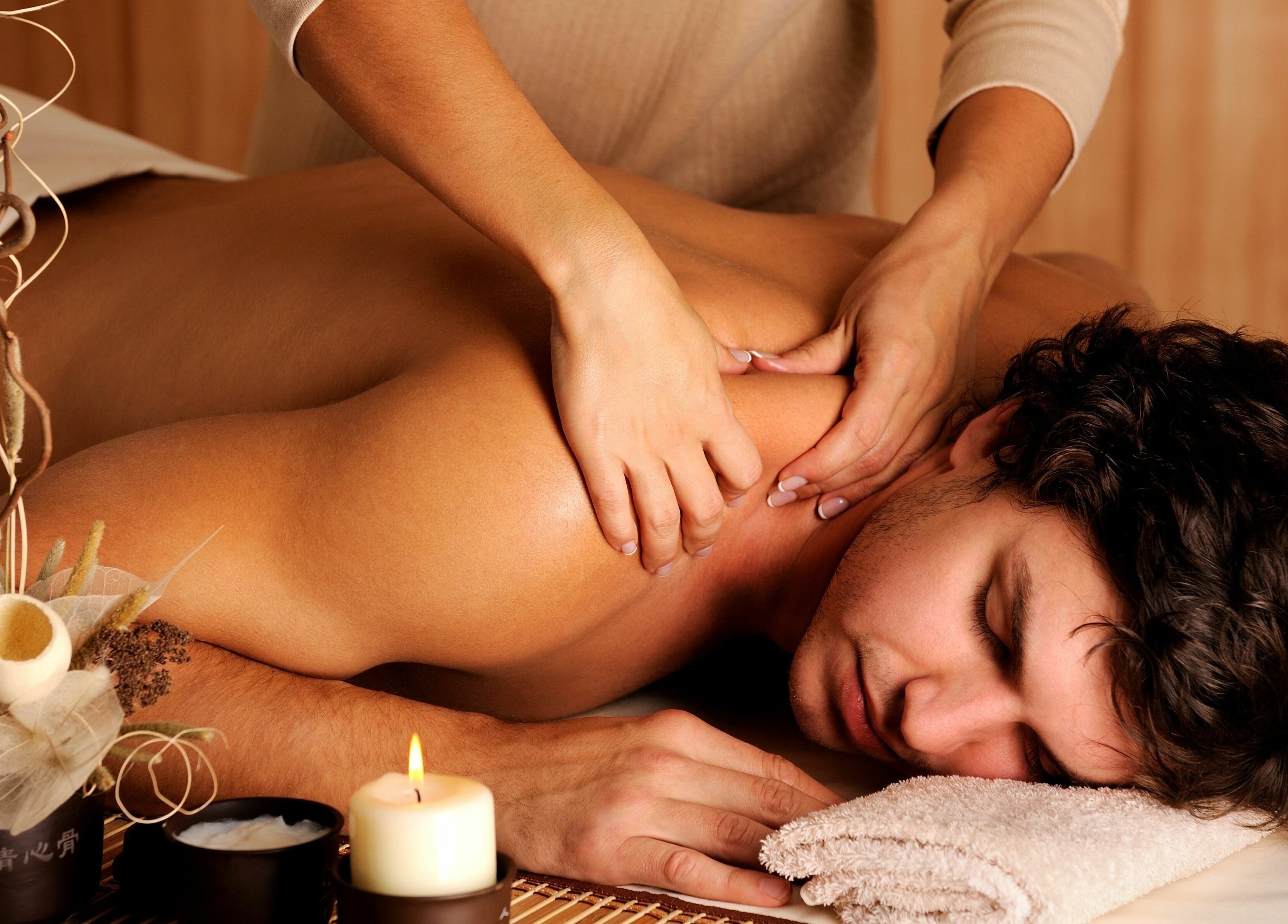 Therapist giving a relaxing back massage at RTC Massage, Reston, Virginia, US with candles and decor.