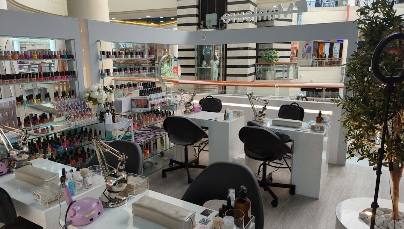 Nails Rituals Kiosk For Him & Her offers manicures in Abu Dhabi, AE. A serene setting with colorful polish displays.