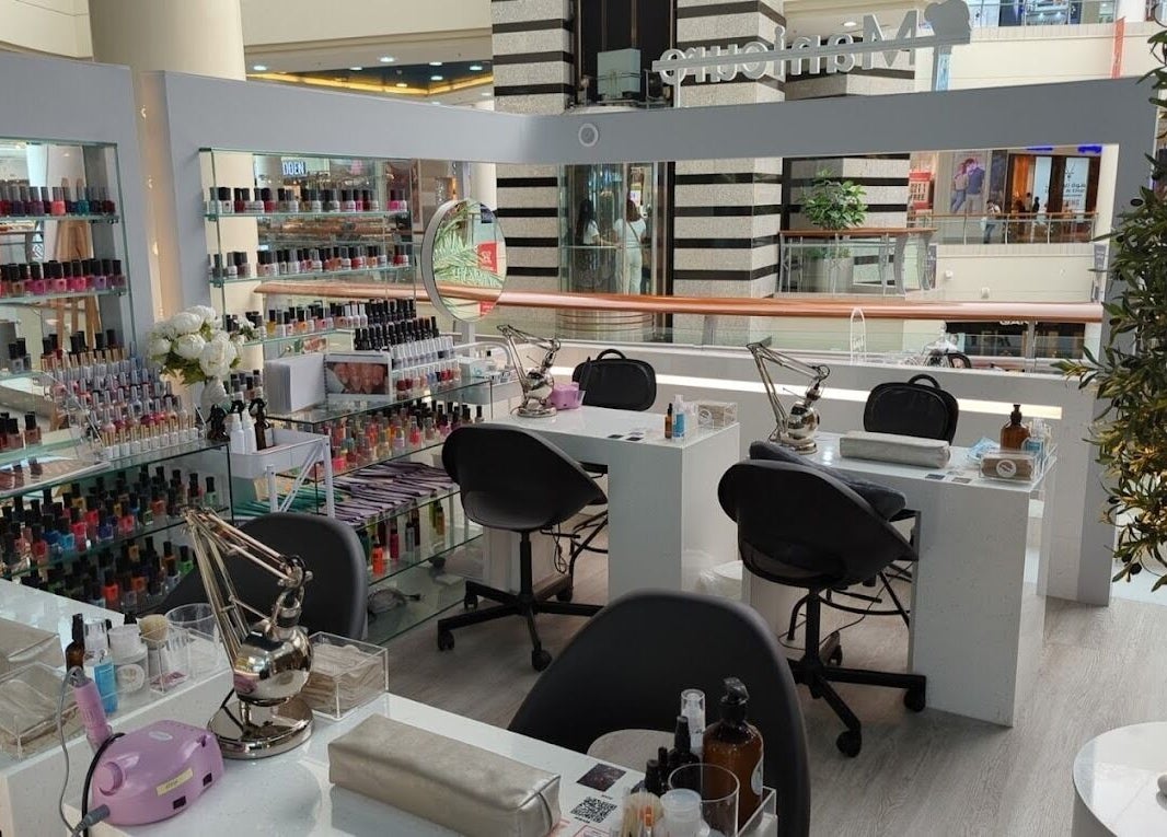 Nails Rituals Kiosk For Him & Her offers manicures in Abu Dhabi, AE. A serene setting with colorful polish displays.