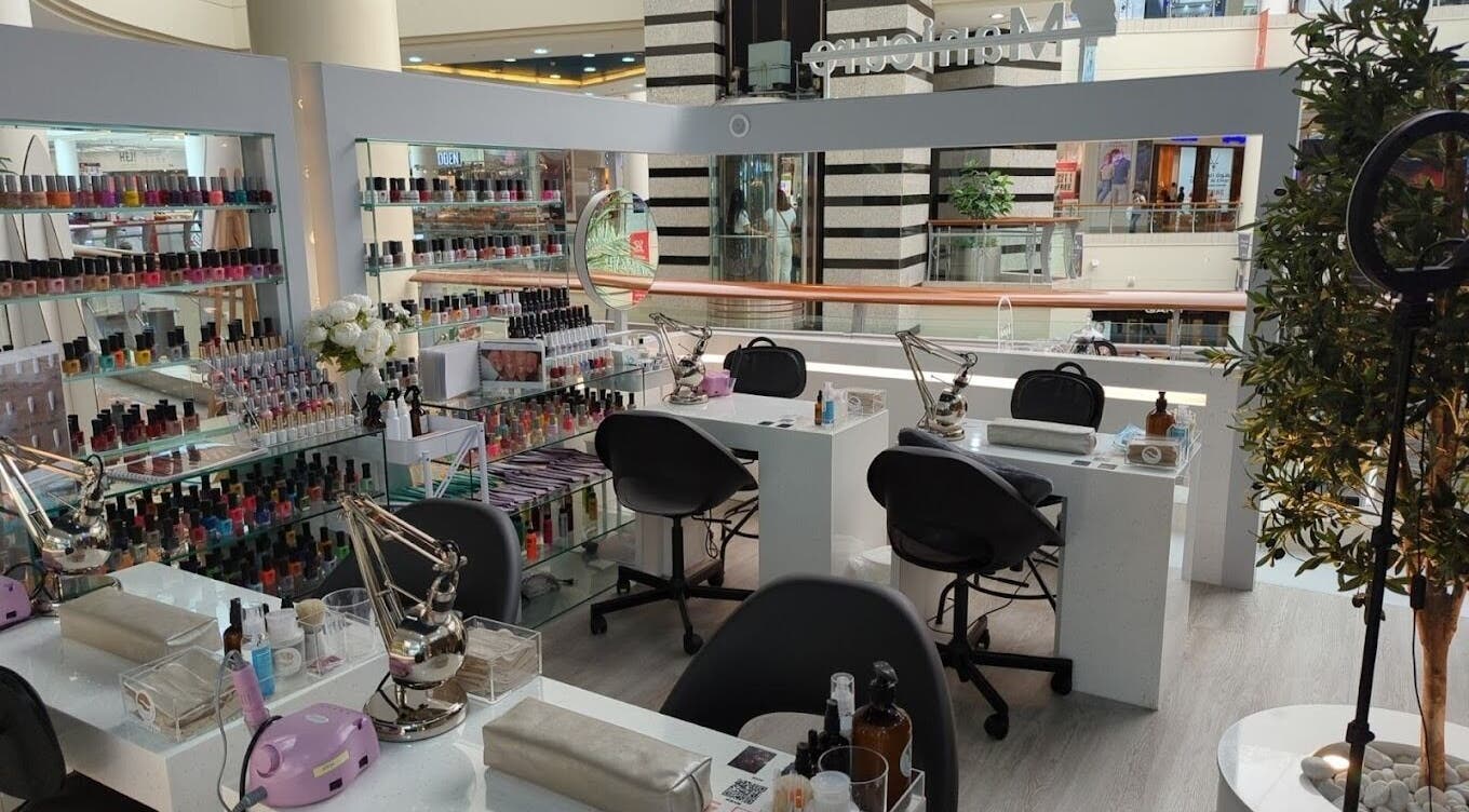 Nails Rituals Kiosk For Him & Her offers manicures in Abu Dhabi, AE. A serene setting with colorful polish displays.