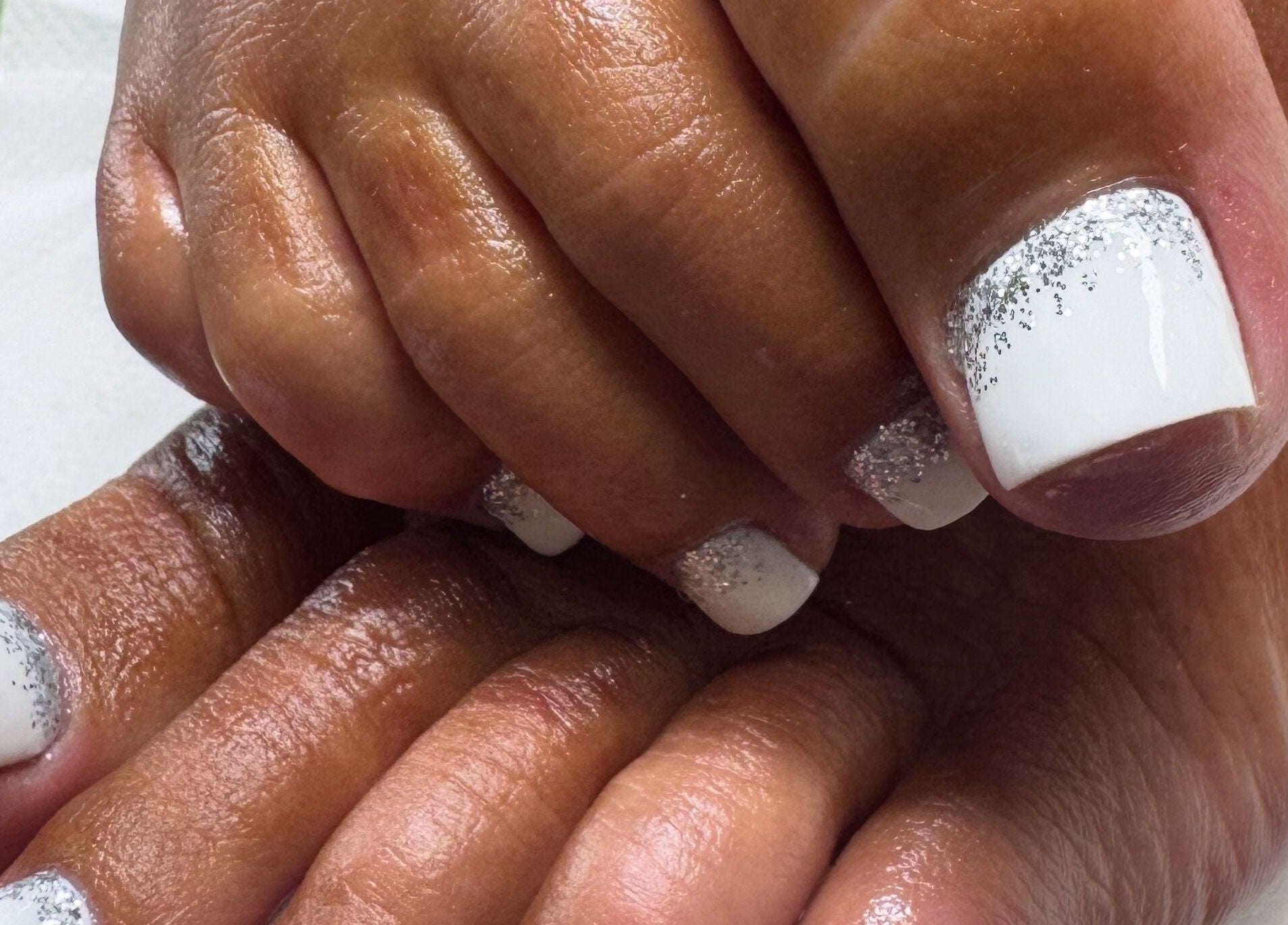 Elegant pedicure with white and silver glitter at Lara McLeish Beauty Box, Rhiwlas, Wales, GB.