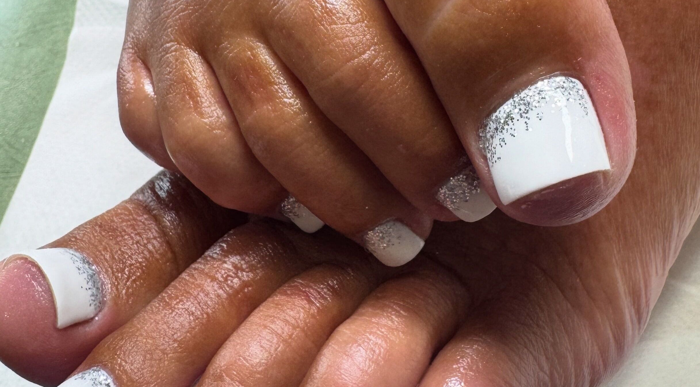 Elegant pedicure with white and silver glitter at Lara McLeish Beauty Box, Rhiwlas, Wales, GB.