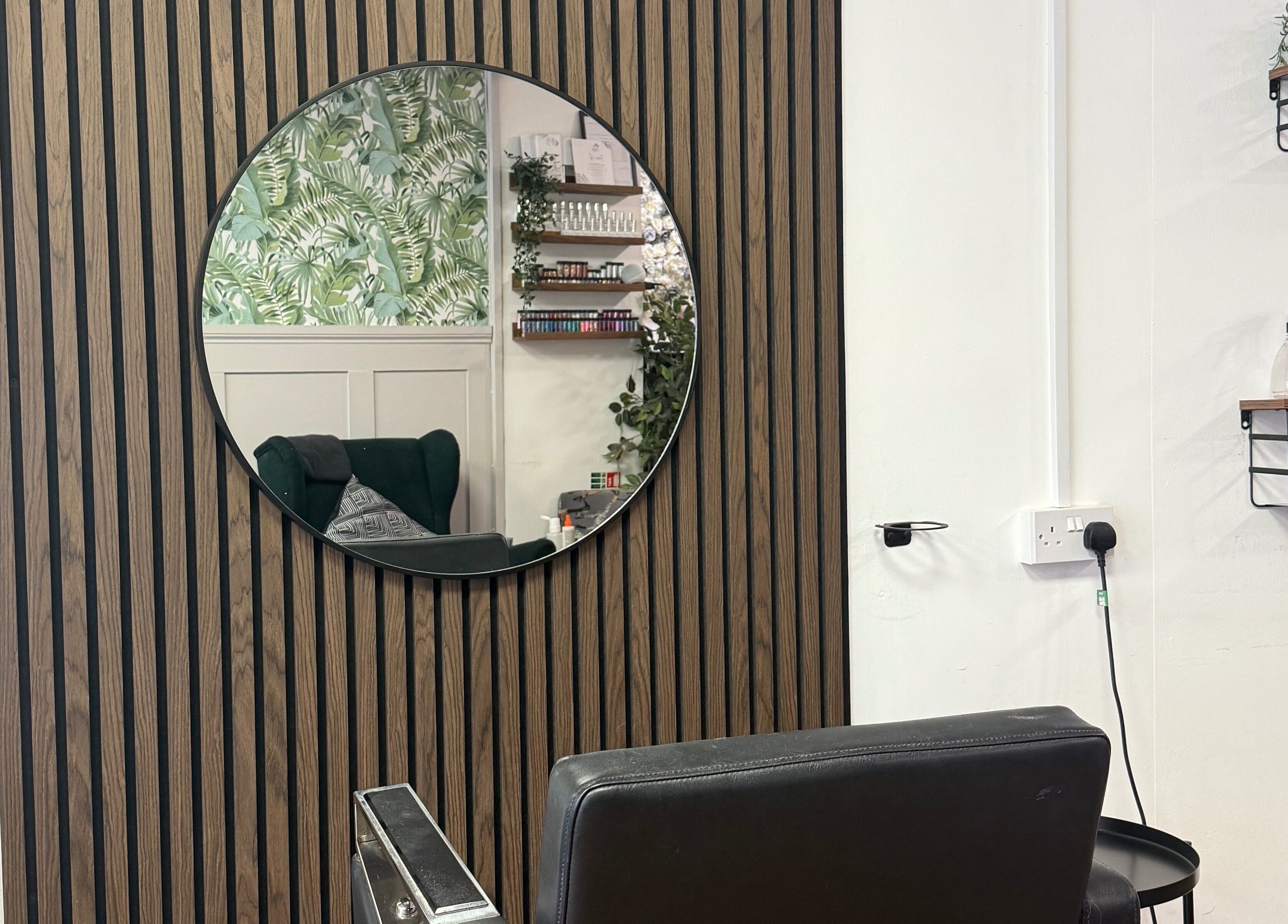 Chic styling chair in Keelys salon, Faringdon, England, GB, with a modern mirror reflecting botanical decor.