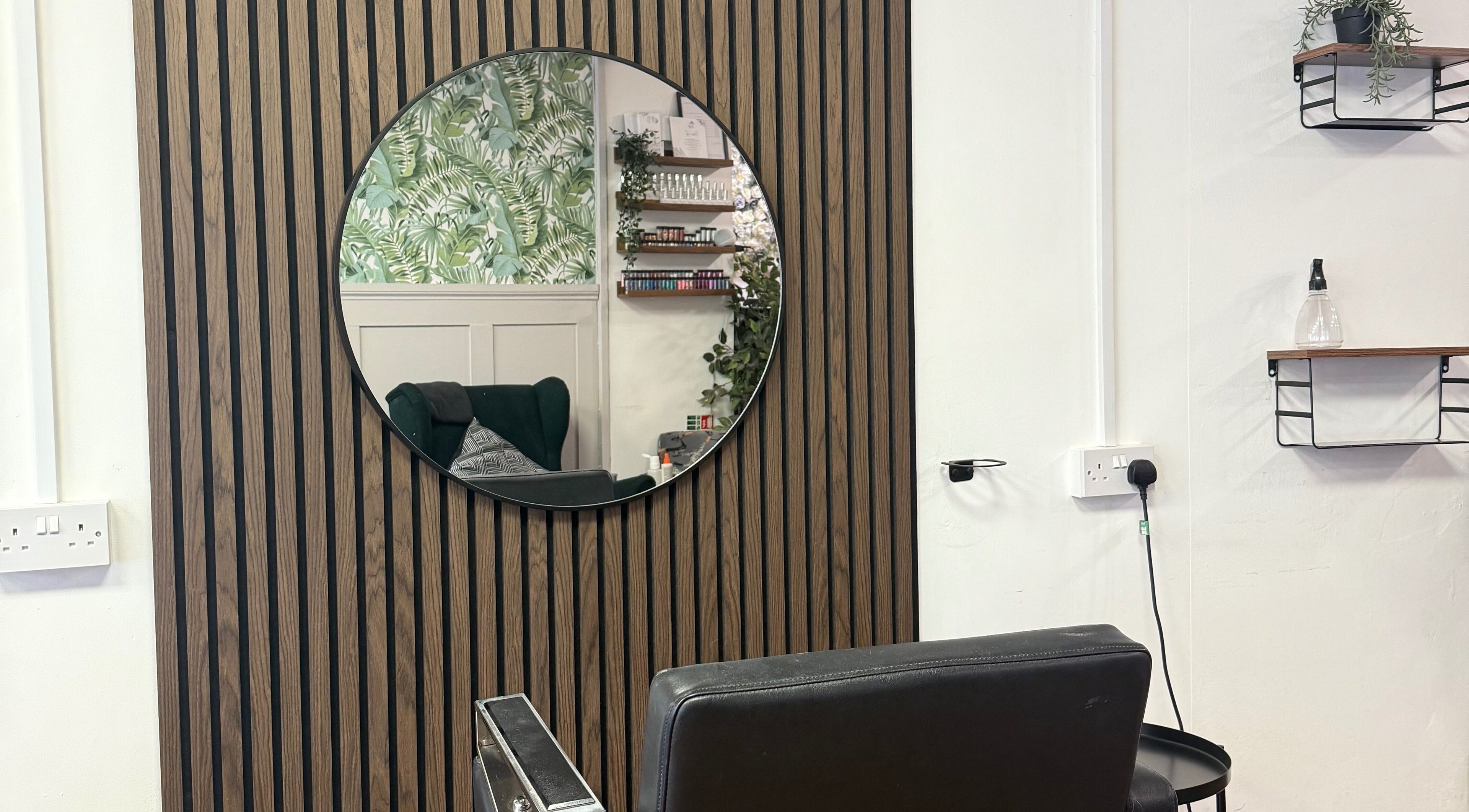 Chic styling chair in Keelys salon, Faringdon, England, GB, with a modern mirror reflecting botanical decor.