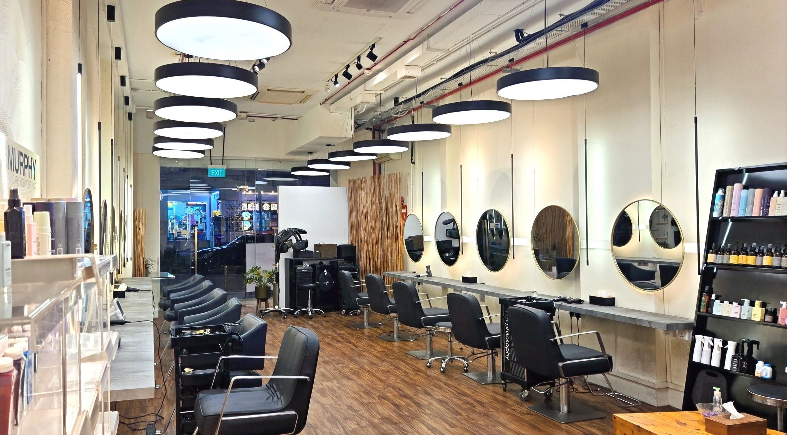 Modern salon interior of Philosophy Studio in Singapore, Singapore, SG with stylish seating and chic mirrors.