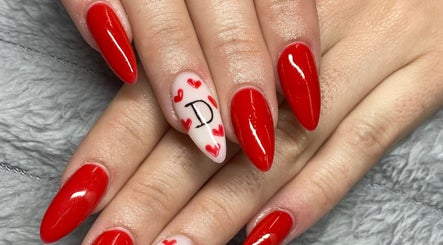 Red manicured nails with heart design by Azalea Beauty Spa, Tzaneen, Limpopo, ZA.
