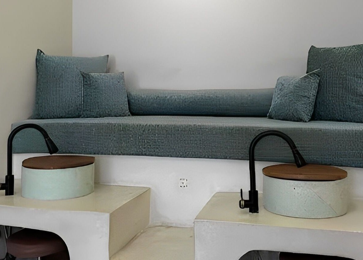 Cozy seating area for pedicures at Kind - Nails & Spa, Bali, Bali, ID with teal cushions and modern basins.