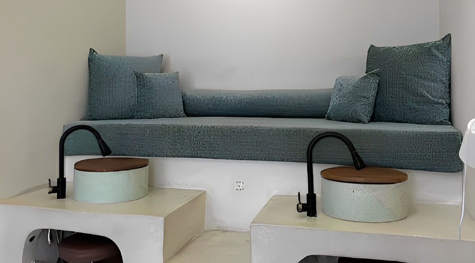 Cozy seating area for pedicures at Kind - Nails & Spa, Bali, Bali, ID with teal cushions and modern basins.