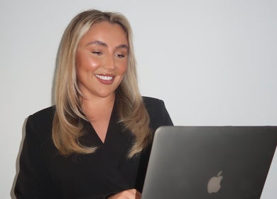 Smiling person with laptop at Cosmetics By Chlo, Westhoughton, England, GB.