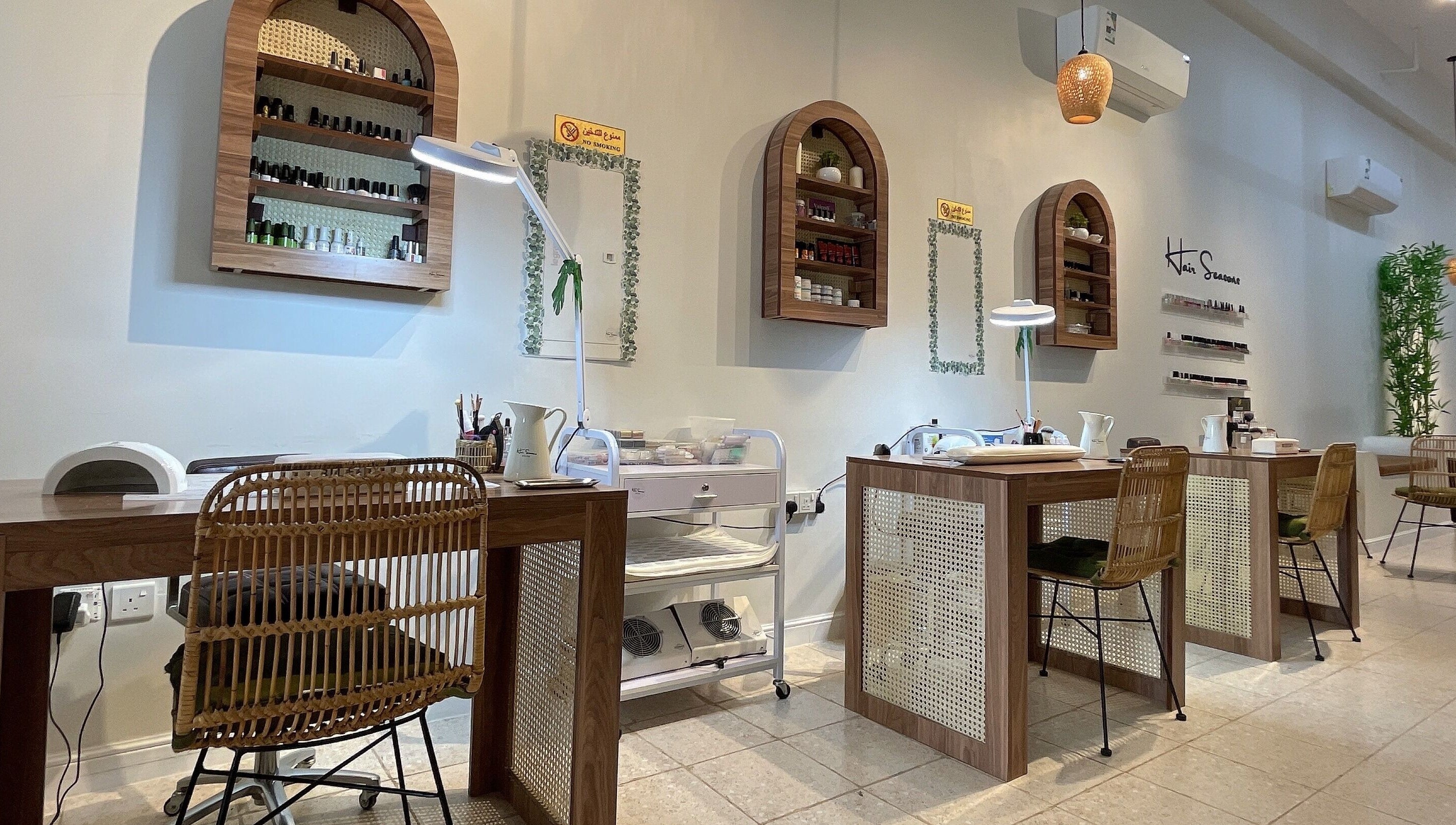 Elegant nail salon stations at Hair Seasons, الرياض, منطقة الرياض, SA, with wooden tables and wicker chairs.