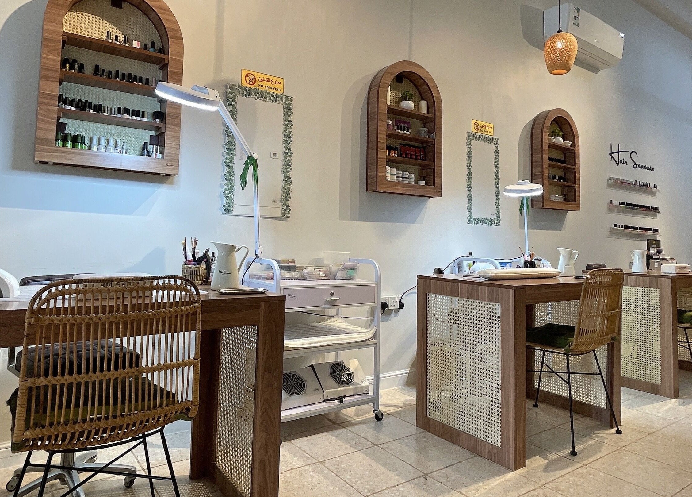Elegant nail salon stations at Hair Seasons, الرياض, منطقة الرياض, SA, with wooden tables and wicker chairs.