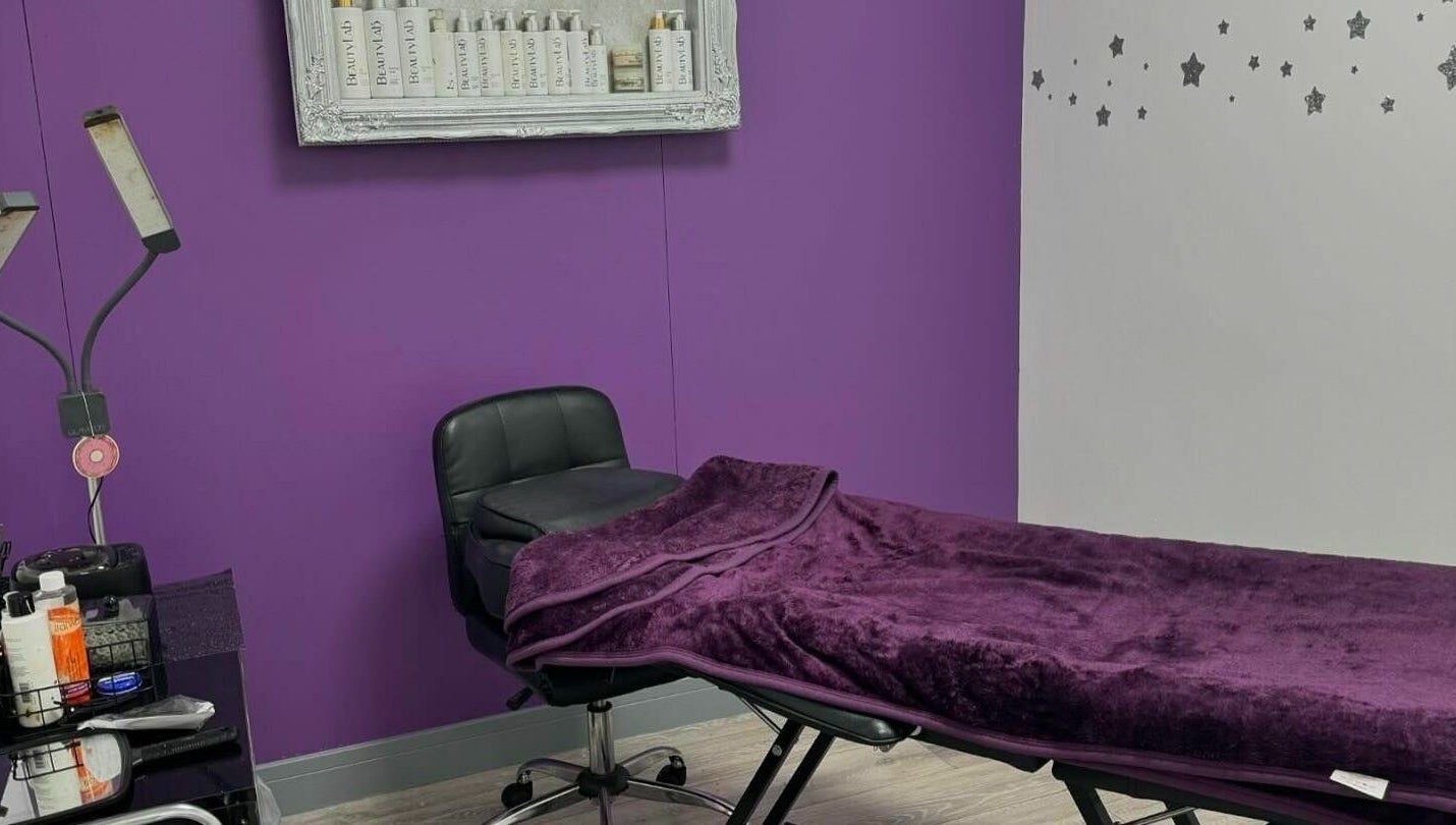 Relaxing treatment room at Mirror Mirror, Aylesford, England, GB with plush purple decor and tranquil ambiance.