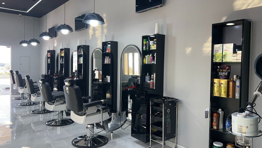 Chic interior at Barb Bros, Dubai, featuring modern barber chairs and styling stations with products.
