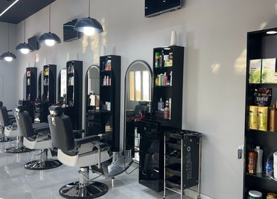 Chic interior at Barb Bros, Dubai, featuring modern barber chairs and styling stations with products.