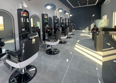 Modern barber chairs and mirrors at Barb Bros, Dubai, Dubai, AE with stylish interior design.