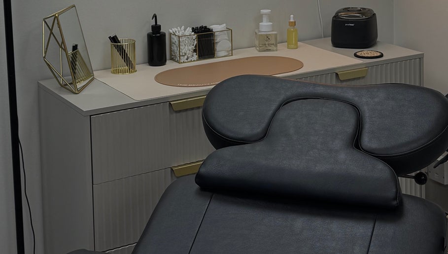Modern treatment room at LMBEAUTY in Linwood, Scotland, GB featuring a sleek massage chair and chic decor.