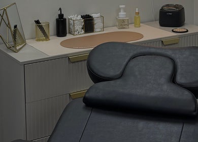 Modern treatment room at LMBEAUTY in Linwood, Scotland, GB featuring a sleek massage chair and chic decor.