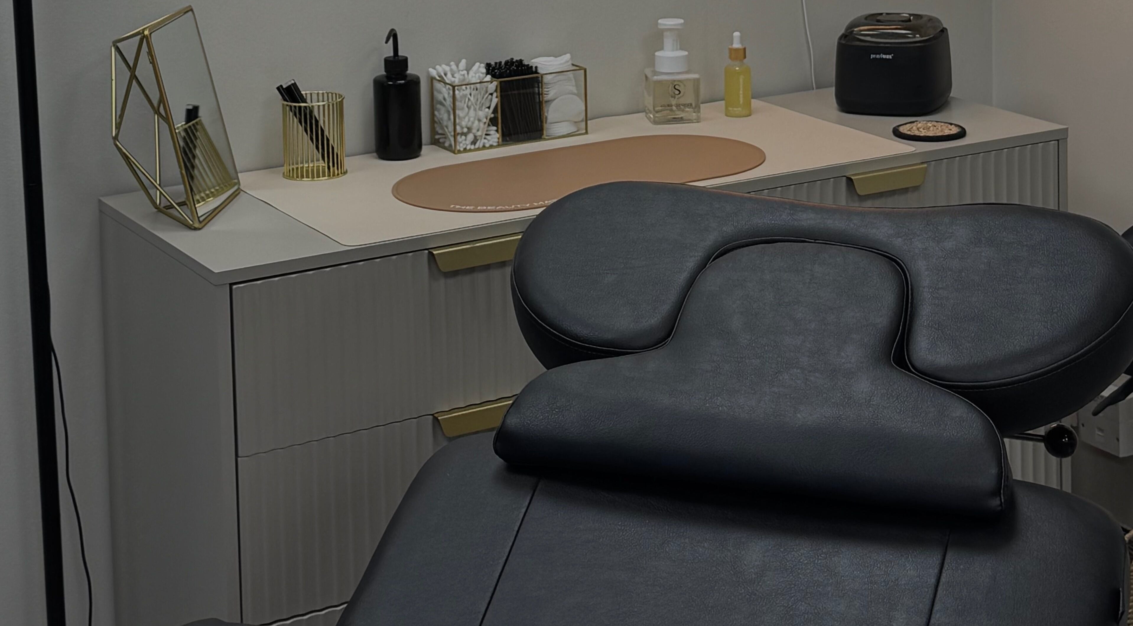 Modern treatment room at LMBEAUTY in Linwood, Scotland, GB featuring a sleek massage chair and chic decor.