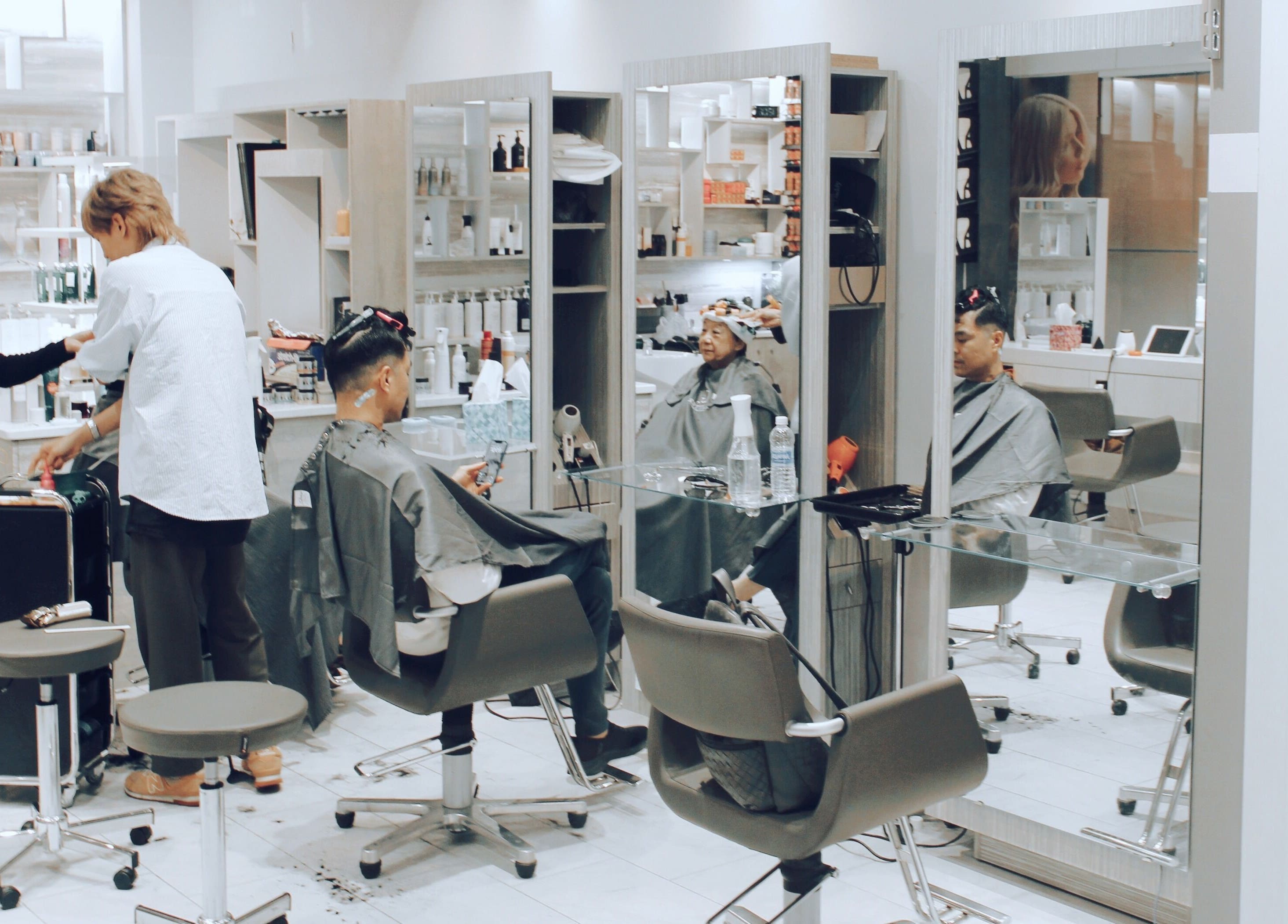 Stylish interior of Nova Salon in New York, New York, US with clients receiving hair treatments.