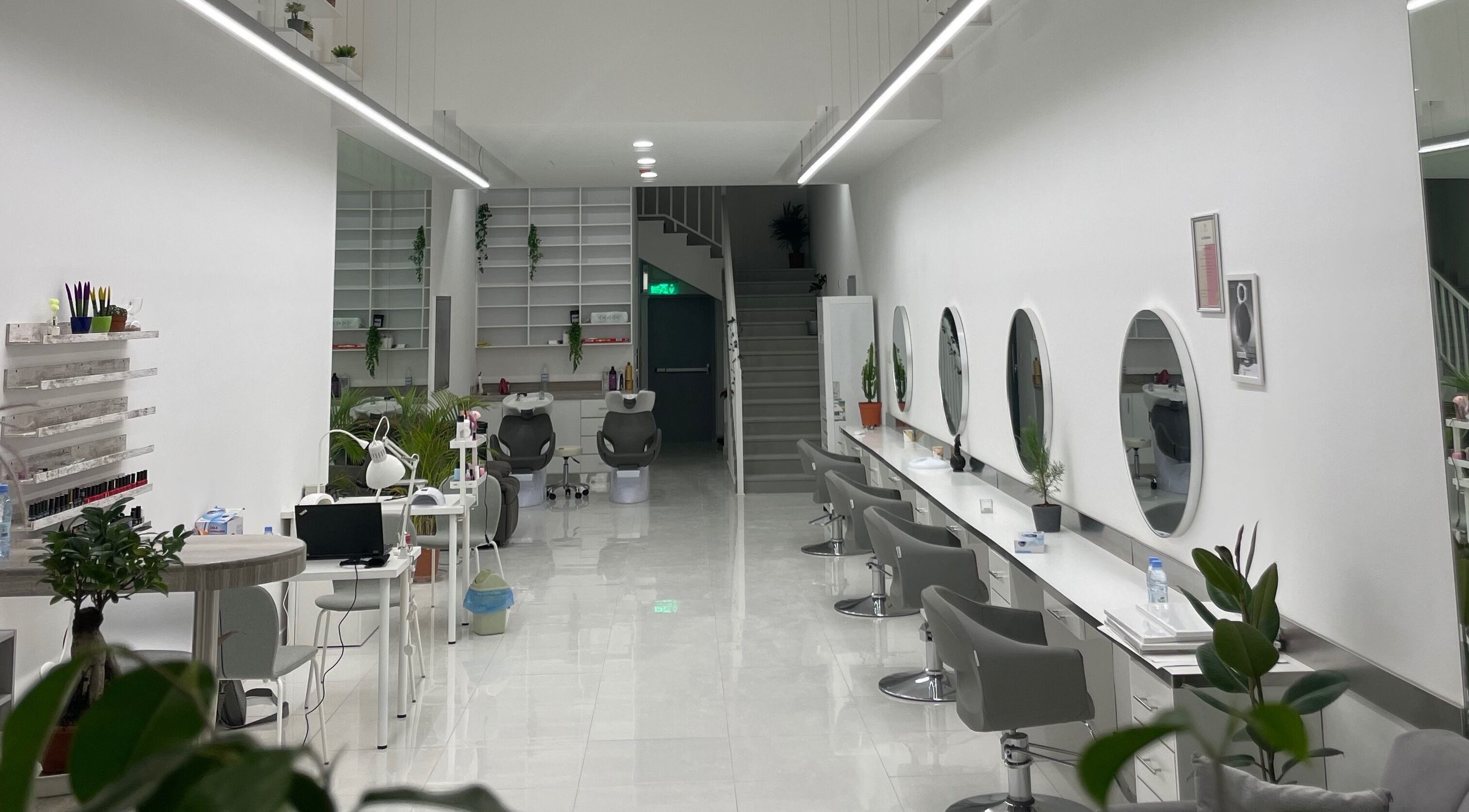 Interior of Ash Beauty Lounge, Riyadh. Modern chairs, mirrors, minimalist decor in white and green accents.