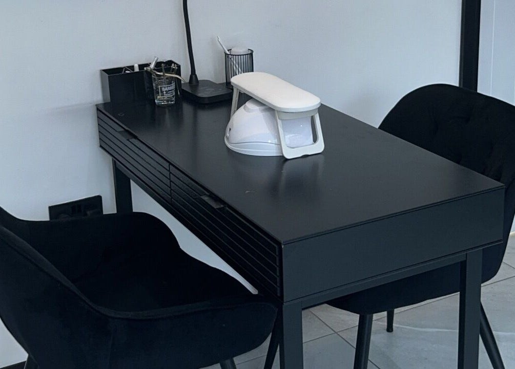 Sleek black manicure station at Glow Salon, Salford, England, GB, with black chairs and modern nail equipment.