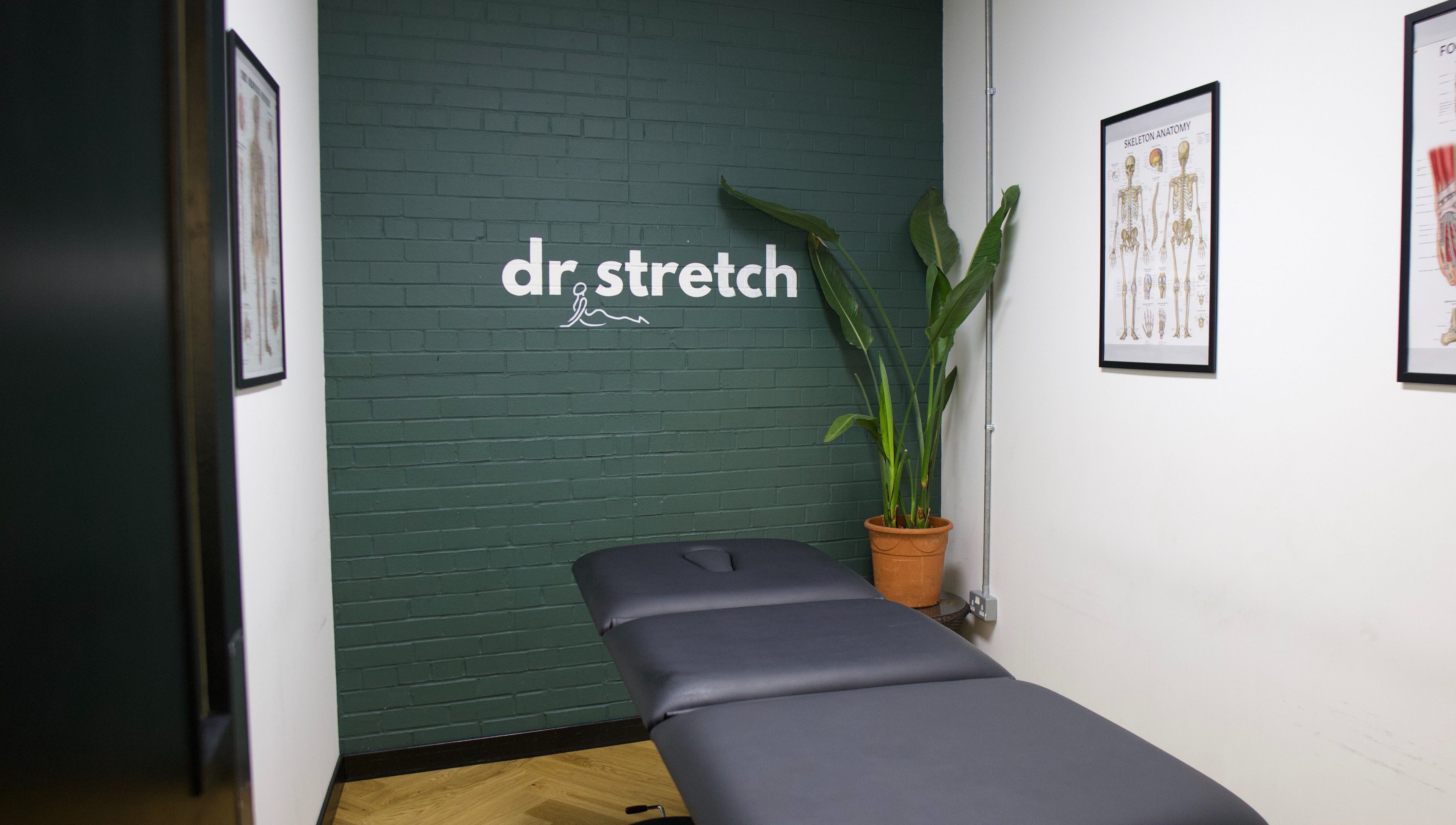 Therapy room at Dr. Stretch - Islington, London, United Kingdom, GB with massage table and anatomy charts.