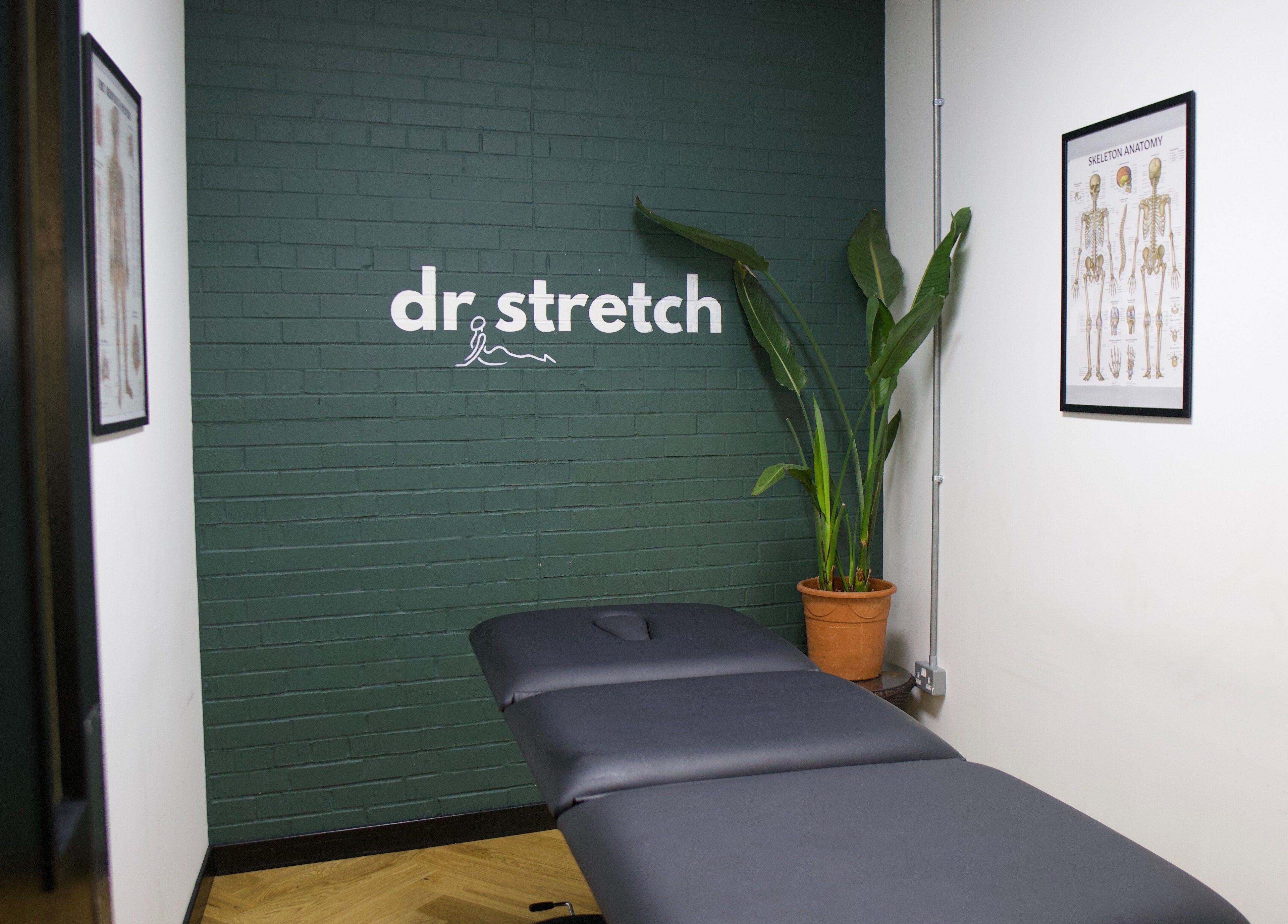 Therapy room at Dr. Stretch - Islington, London, United Kingdom, GB with massage table and anatomy charts.