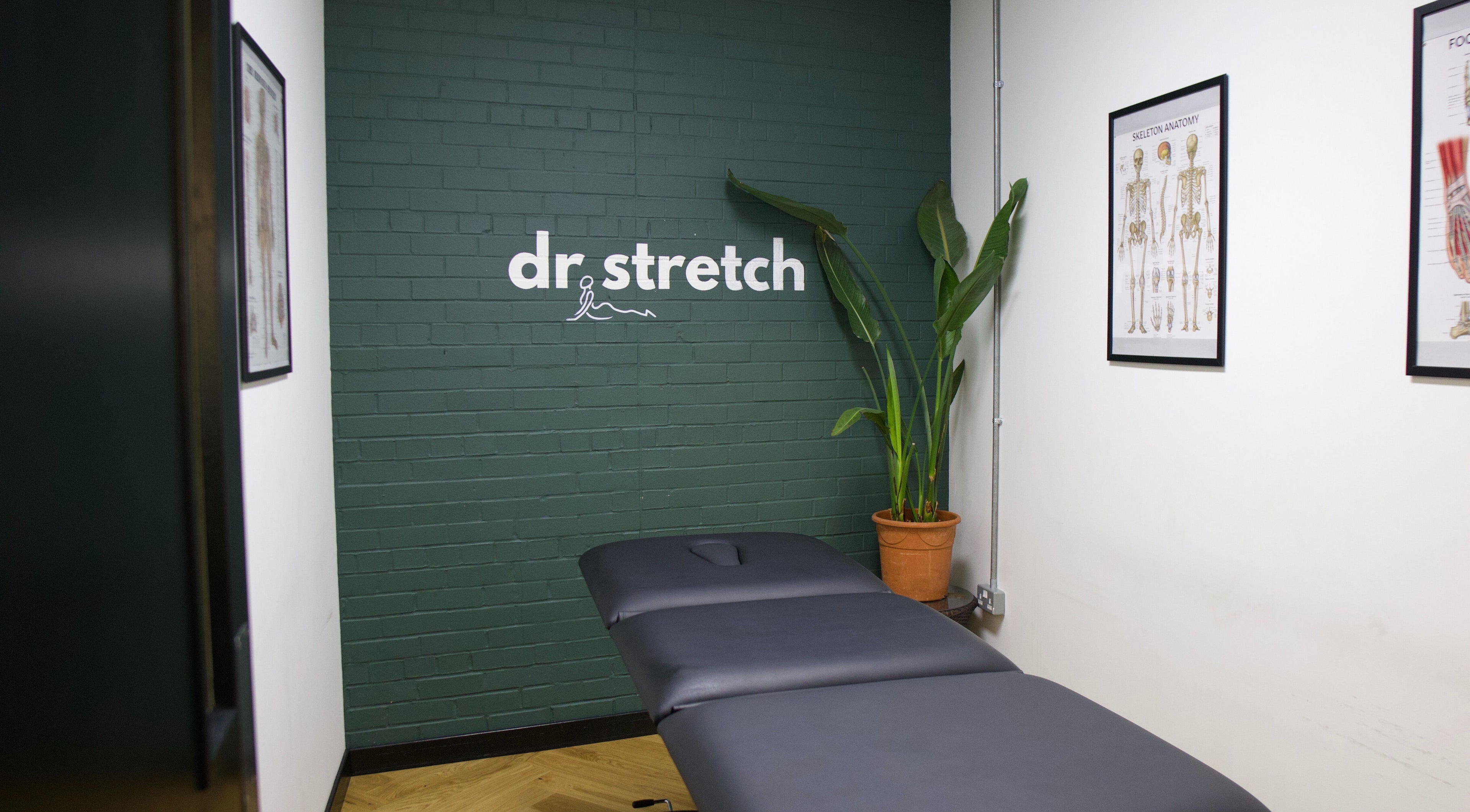 Therapy room at Dr. Stretch - Islington, London, United Kingdom, GB with massage table and anatomy charts.