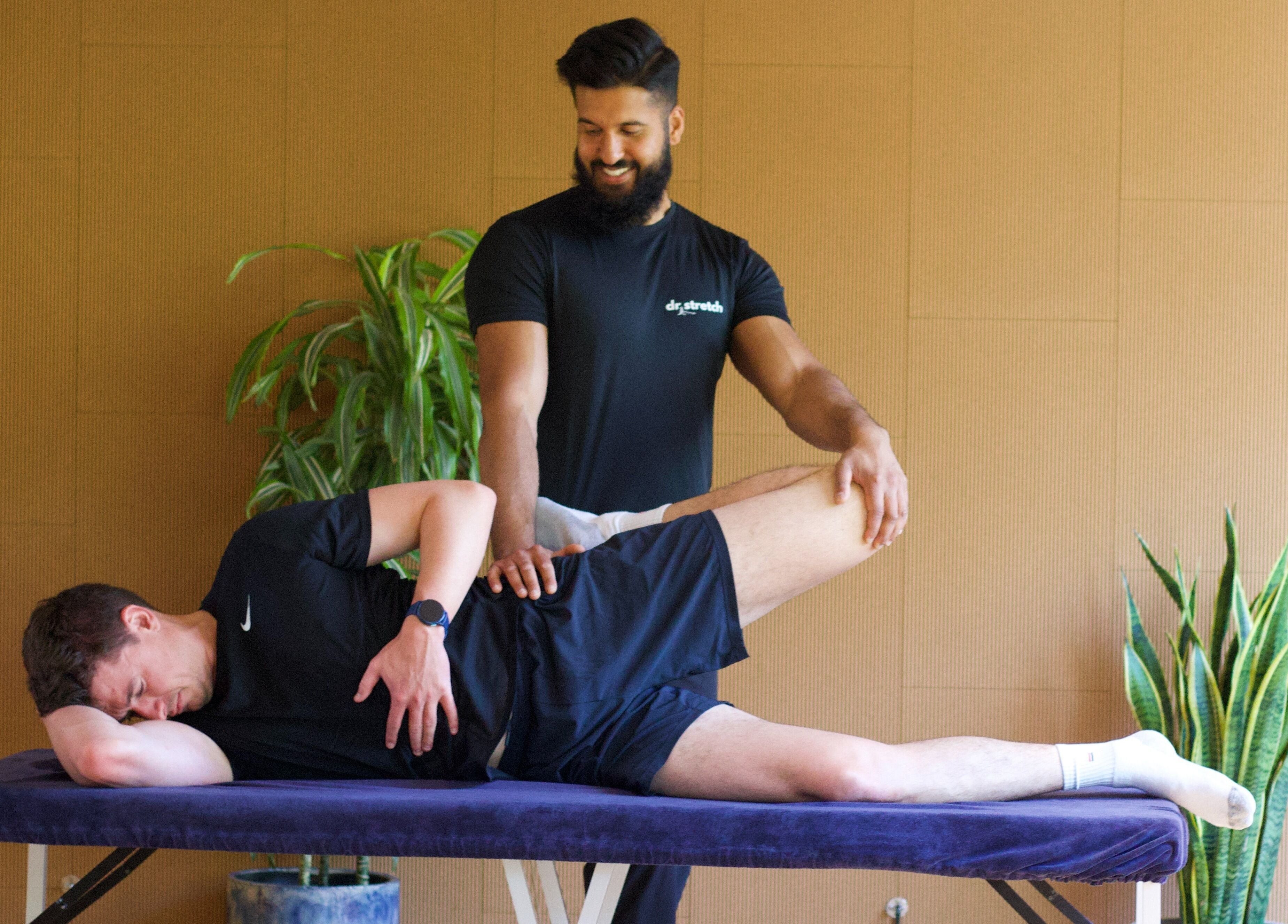 Therapist stretches client's leg at Dr. Stretch - Islington, London, United Kingdom, GB.