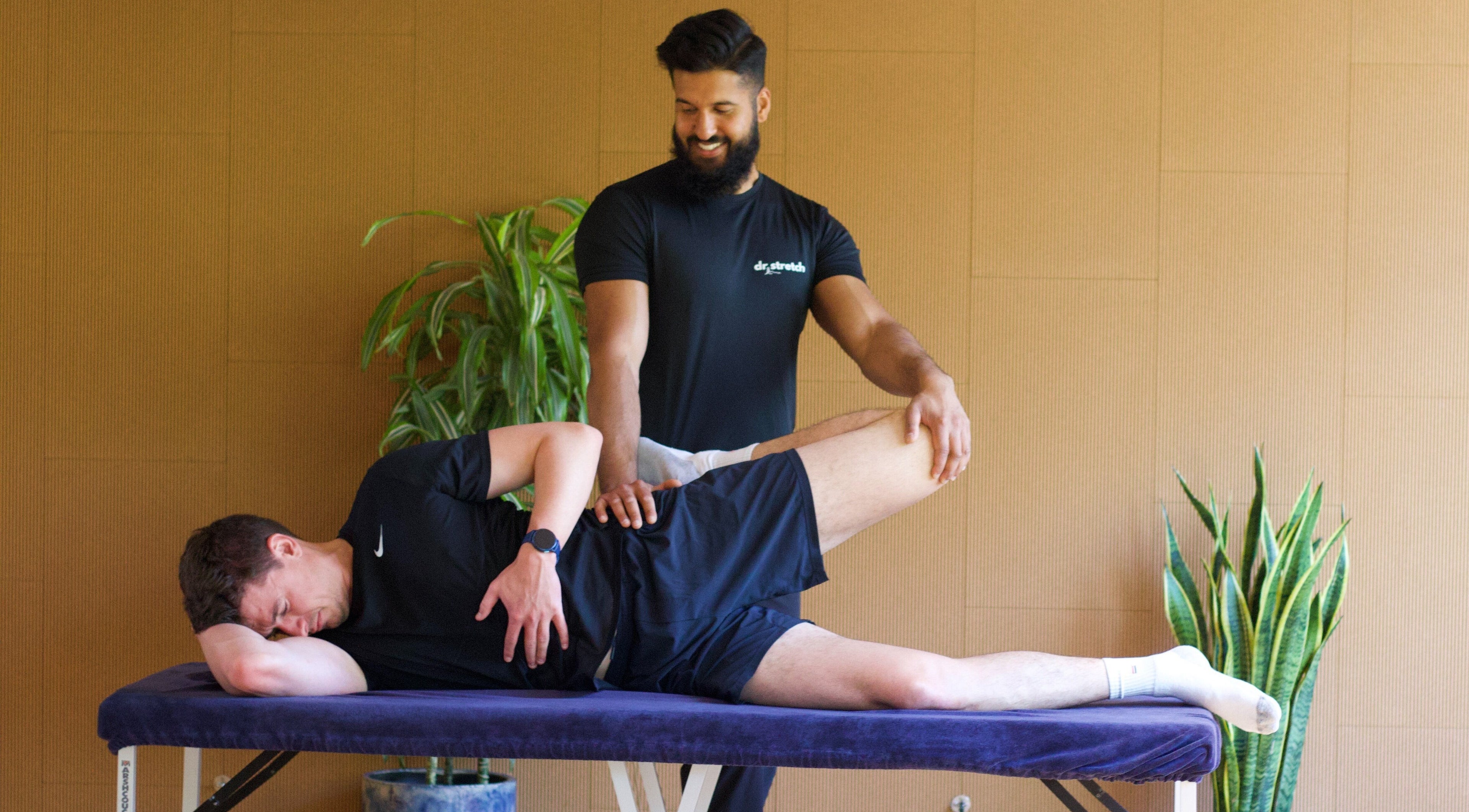 Therapist stretches client's leg at Dr. Stretch - Islington, London, United Kingdom, GB.