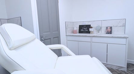 Relaxing treatment room at New Age Aesthetics, Doncaster, England, GB. Modern decor with a plush white chair.