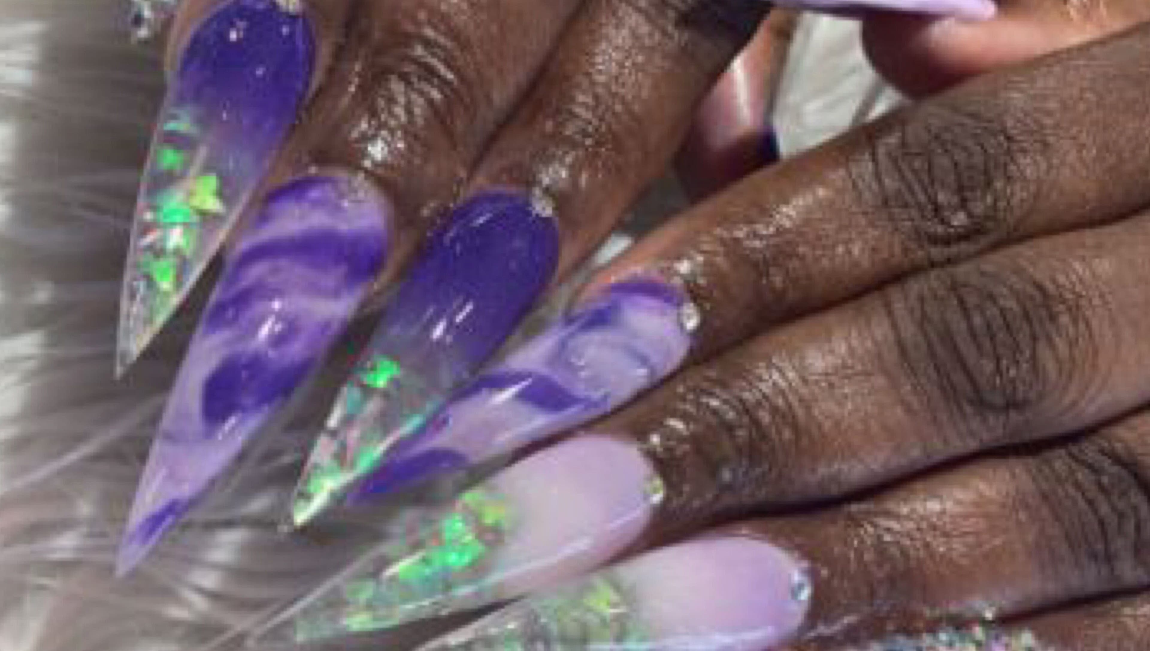 Vibrantly painted marble nails with gems at Palace Nails, Bowling Green, Kentucky, US.