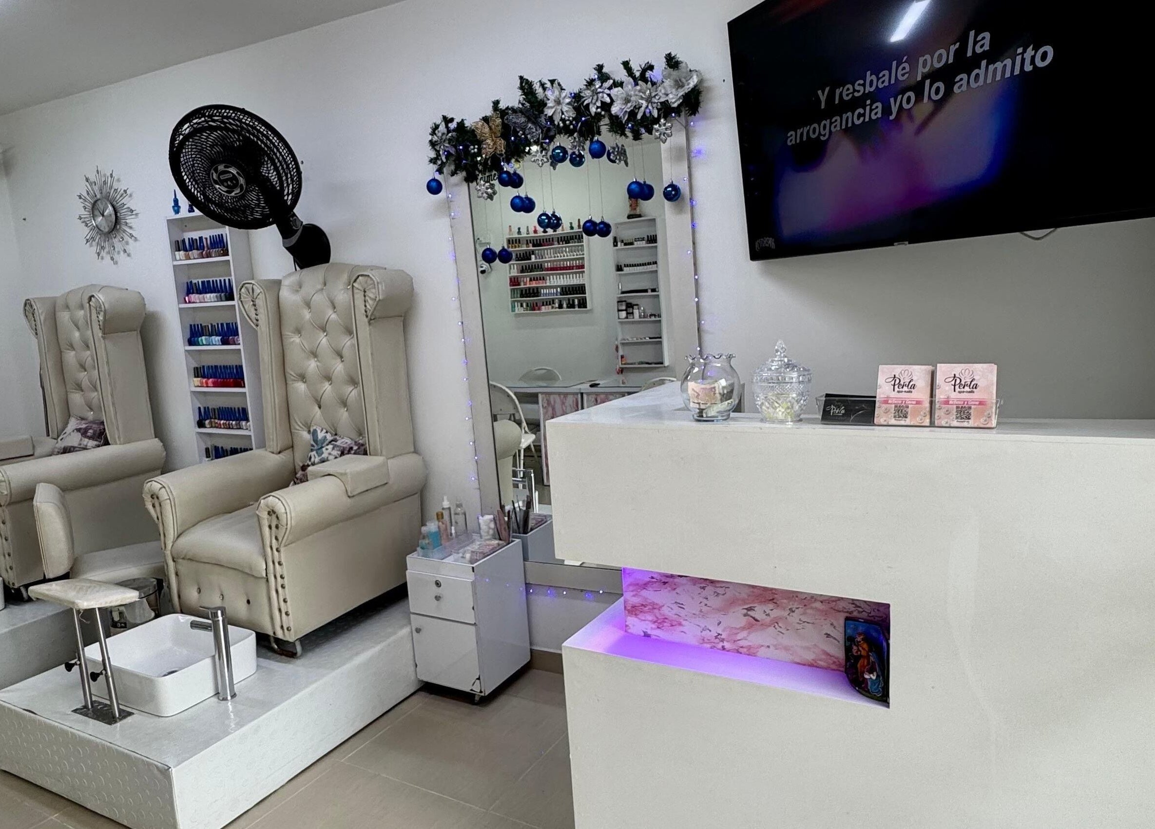 Interior de Perla Spa Nails en Tuluá, Valle Del Cauca, CO, mostrando sillas de manicura elegantes y decoración festiva.